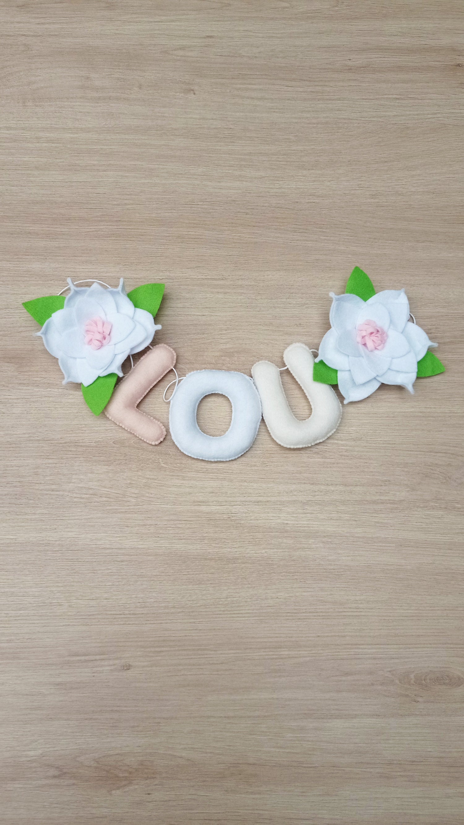 Guirlande prénom et fleurs en feutrine pour décoration de chambre de bébé.