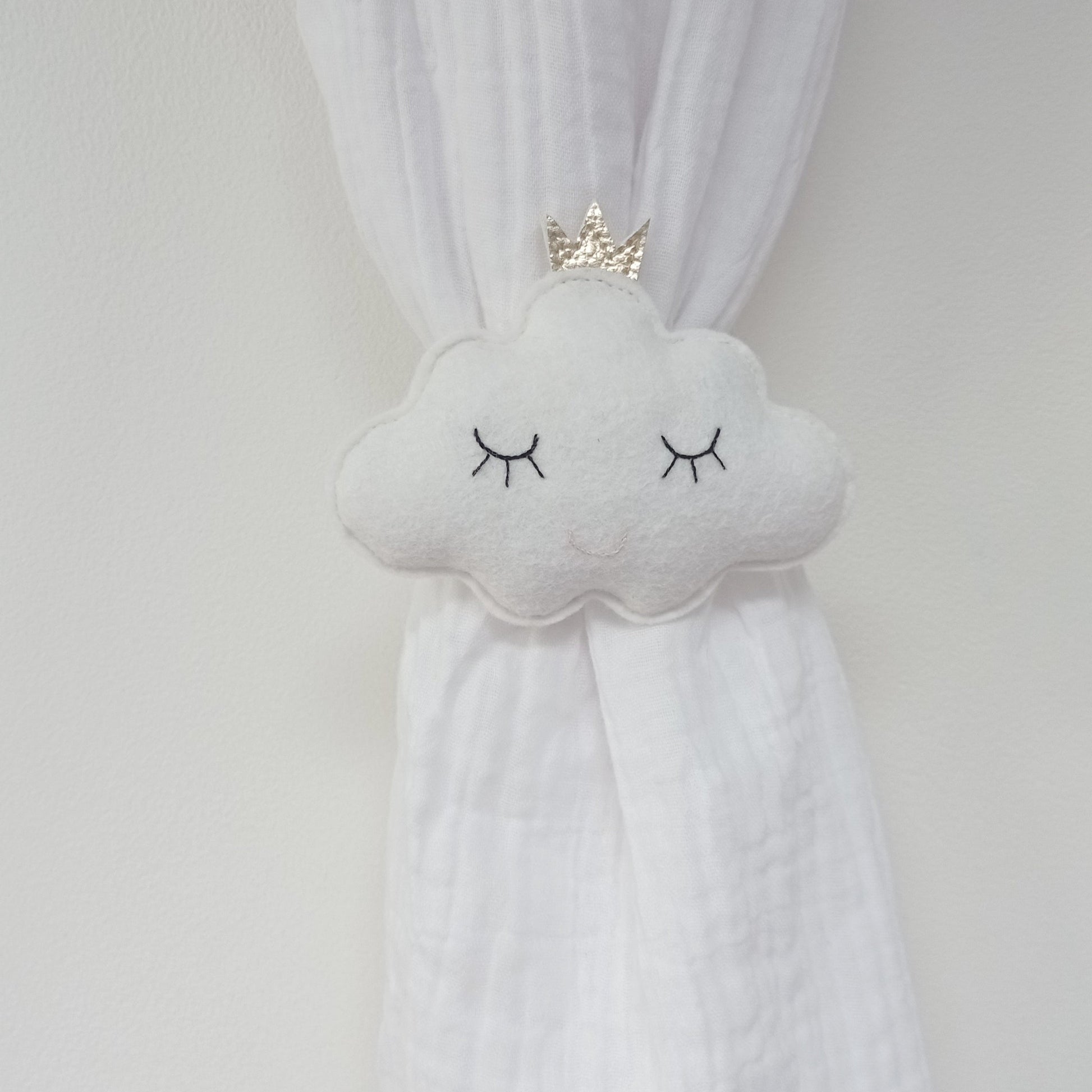 Embrasse décoratif pour enfant en forme de nuage souriant.