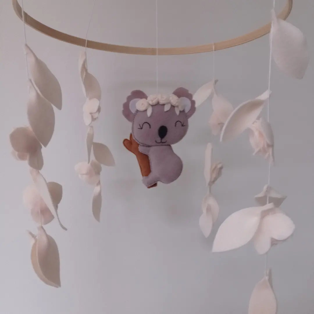 Mobile bébé koala en feutrine fait main avec fleurs blanches.