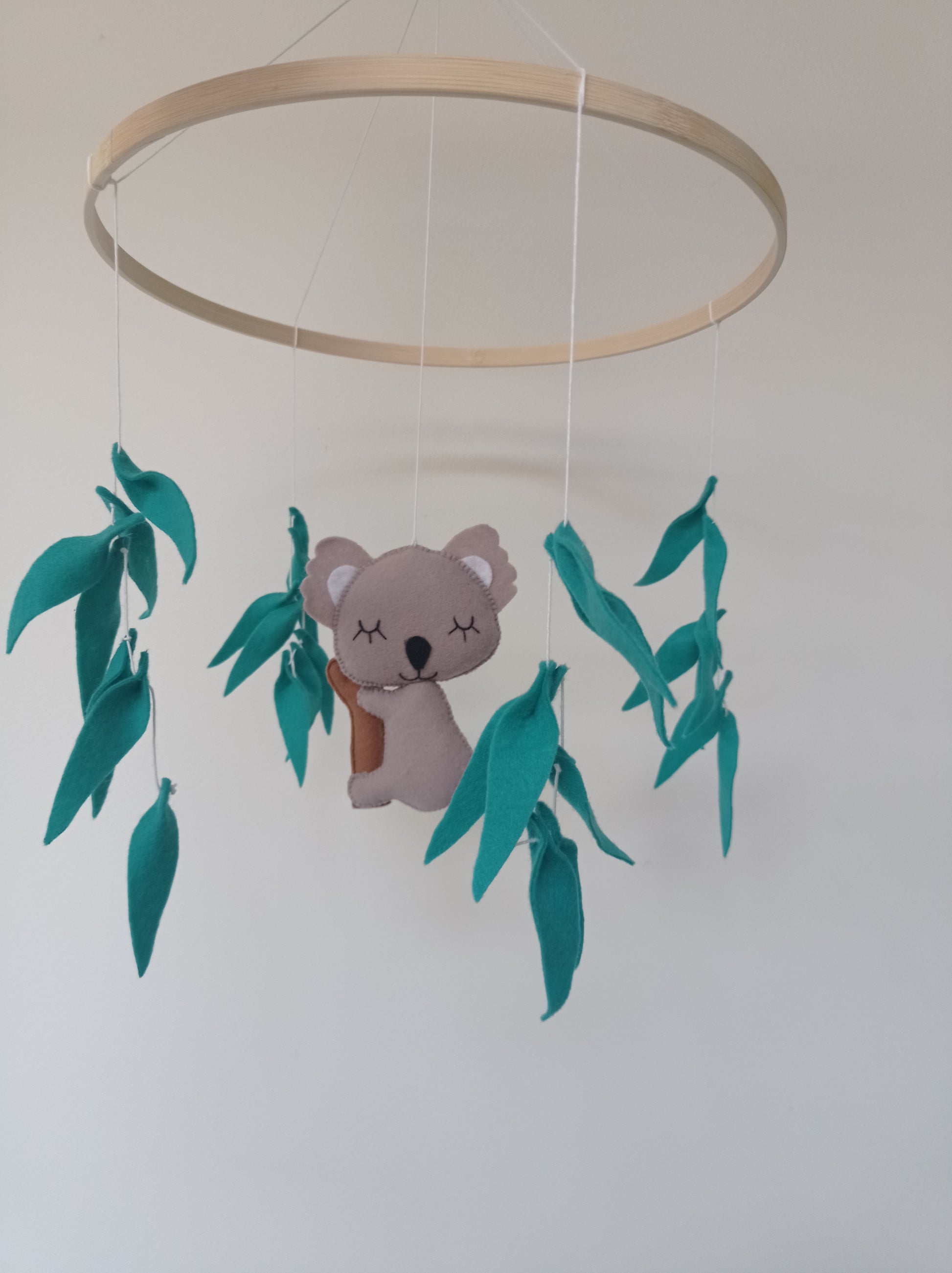 Mobile koala en feutrine et feuilles d'eucalyptus.